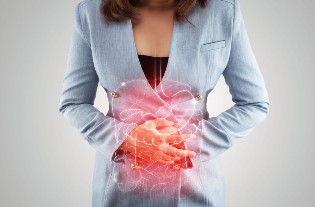 A woman touching her painful stomach due to inflammation of her intestines. A digital illustration of swollen digestive tract.